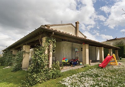 Porticato con colonne in mattoni anticati e copertura con travi in rovere uso fiume
